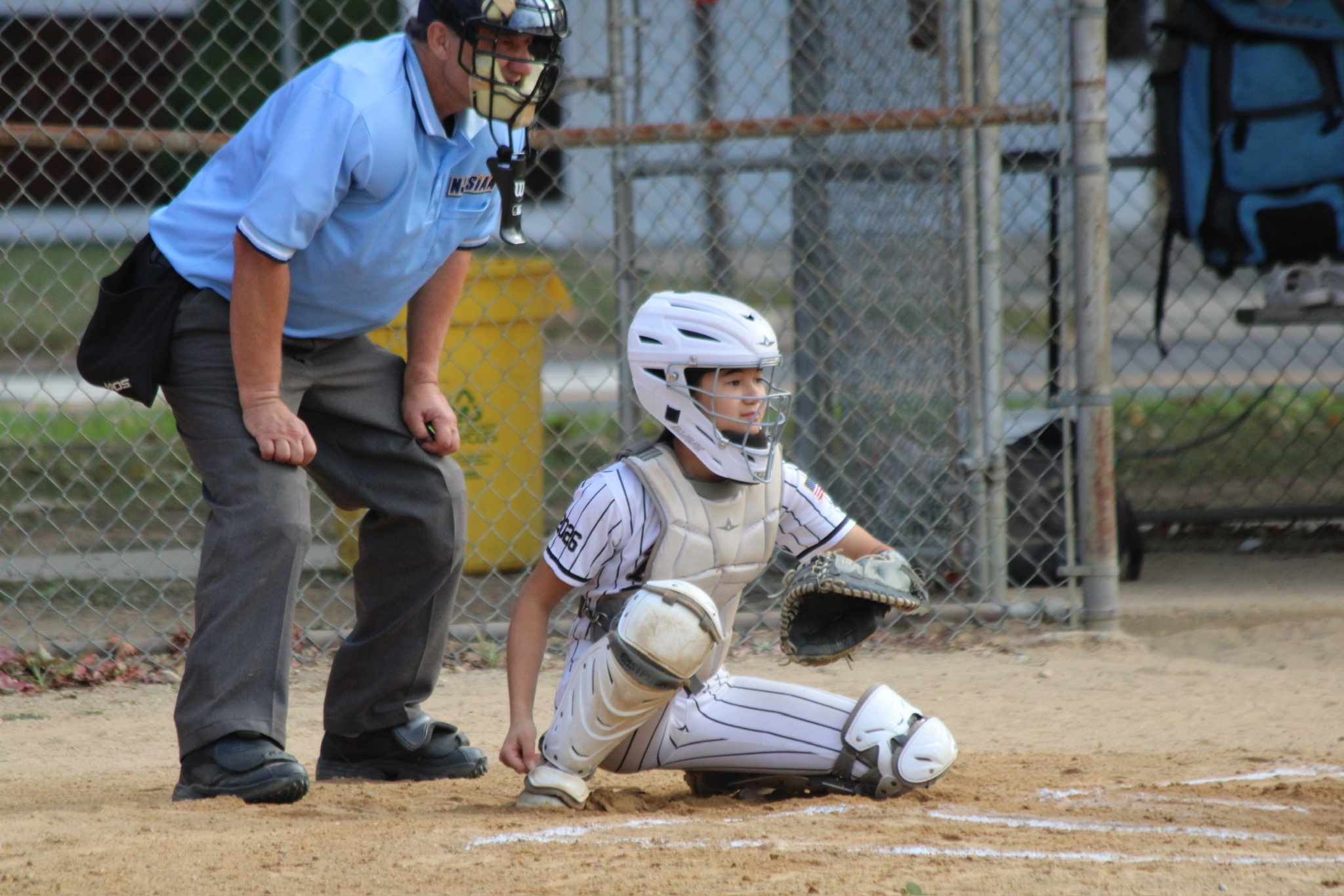 Abigail Han, a Class of 2026 Extra Elite 100 catcher, prepares to receive a pitch during a game for her team.